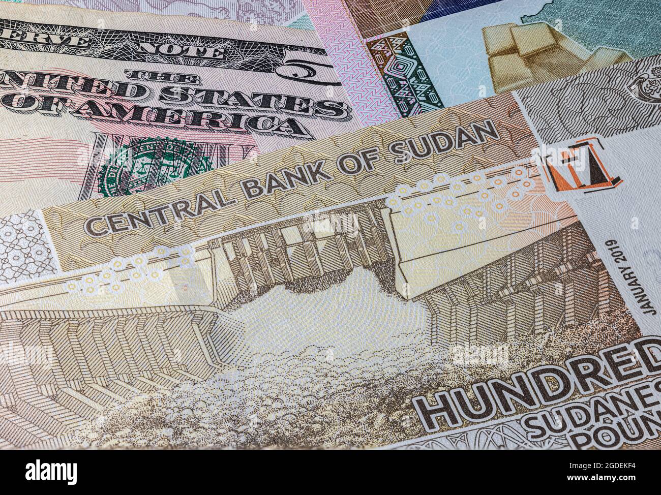 Close up to 100 Sudanese pounds of the Republic Sudan beside US dollars banknotes. 100 Pound banknotes of the African country Sudan. Money US with sud Stock Photo