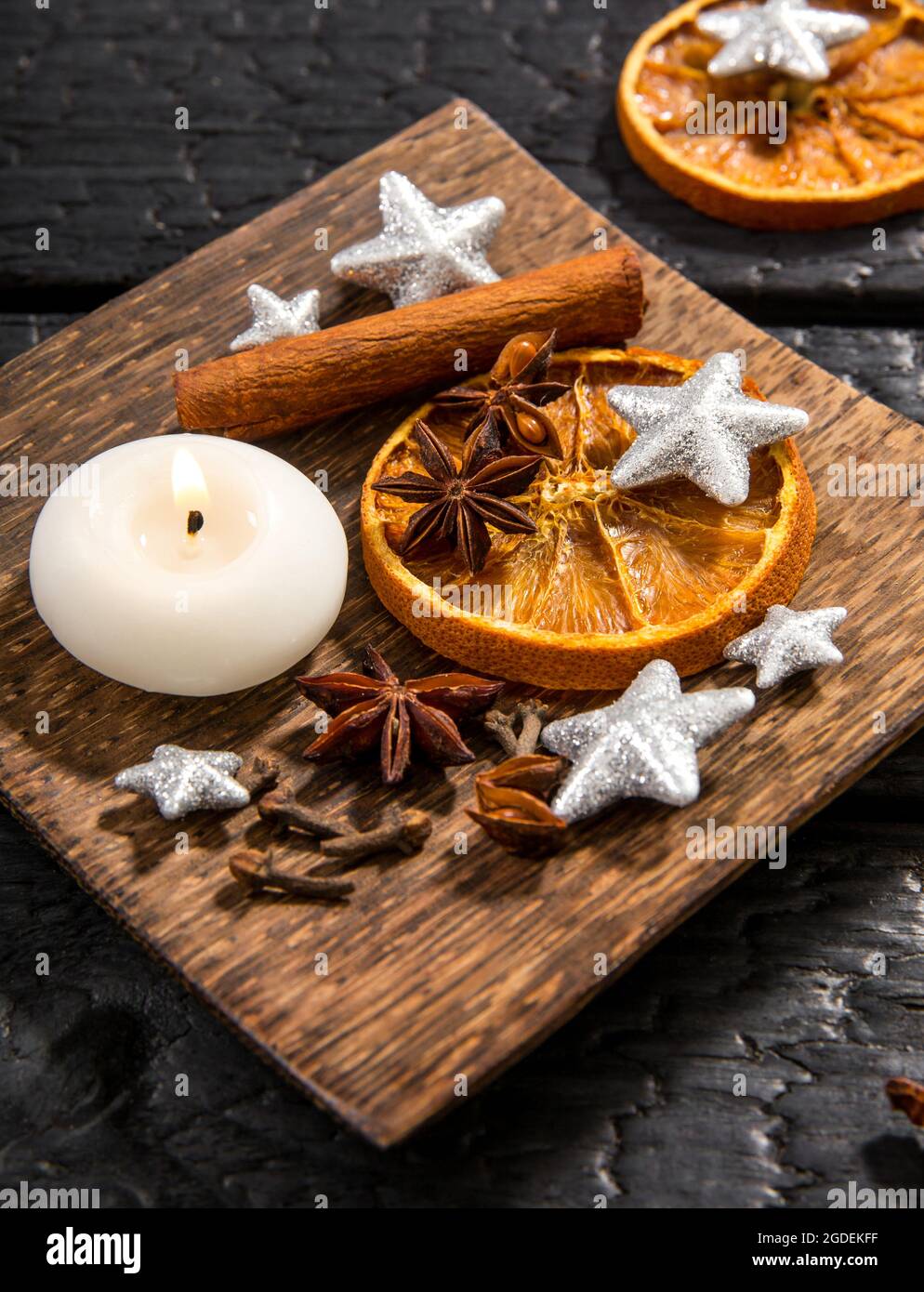 Winter relaxing aromatherapy. Side view of various spices: cinnamon stick, clove, star anise, dried orange slices. Wood tray with seasonal potpourri o Stock Photo