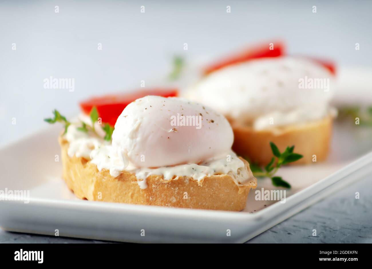 Tasty breakfast. Poached egg with cheese paste and herbs. Healthy food Stock Photo