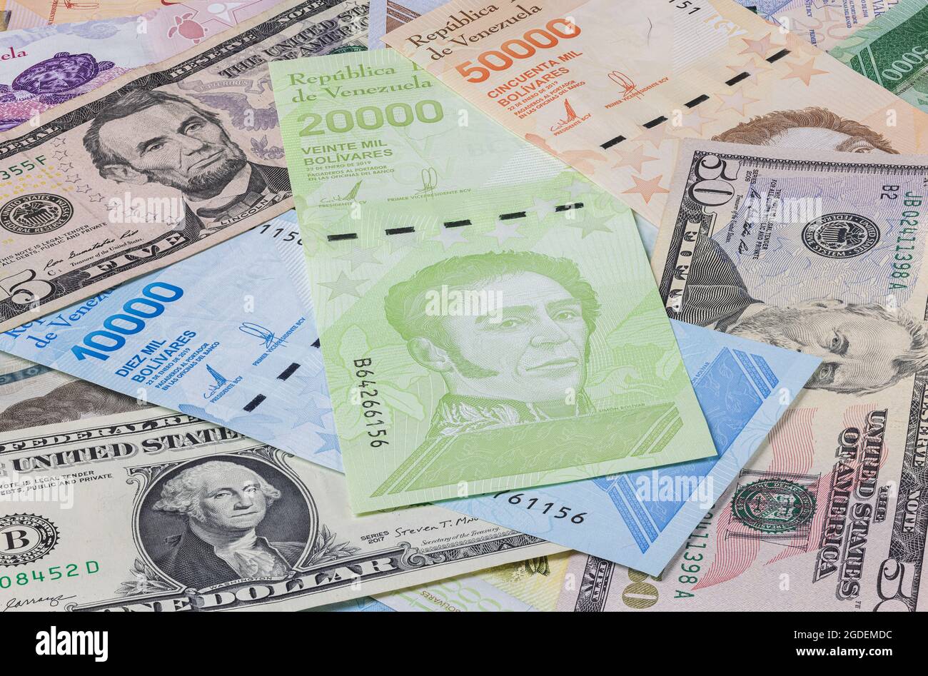 The almost worthless Venezuelan money on a bunch between the strong US dollars. Bolivares or Bolivar, the currency of Venezuela. Inflation lasting for Stock Photo