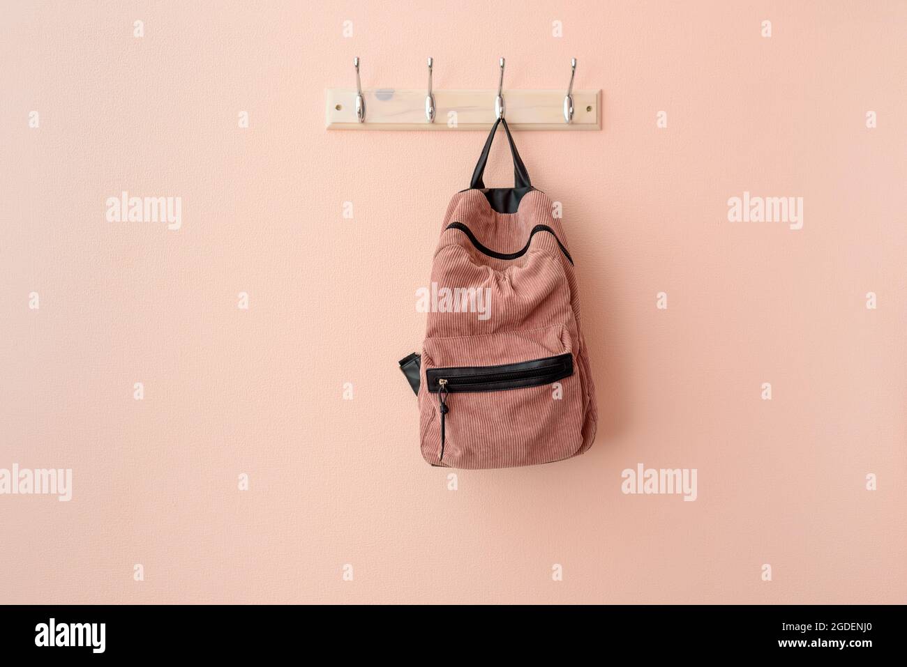 Pink backpack on hook clothes hanger Stock Photo Alamy