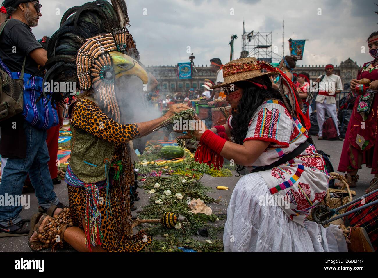 Mexiko Stadt, Mexico. 12th Aug, 2021. A woman performs a purification ritual on a person depicted as an Aztec warrior during the commemoration of the fall of Tenochtitlan. In 2021, Mexico will mark the 500th anniversary of the conquest of the Aztec land by the Spanish. (to dpa: Moctezuma's legacy: Mexico reworks conquest after 500 years) Credit: Jair Cabrera Torres/dpa/Alamy Live News Stock Photo