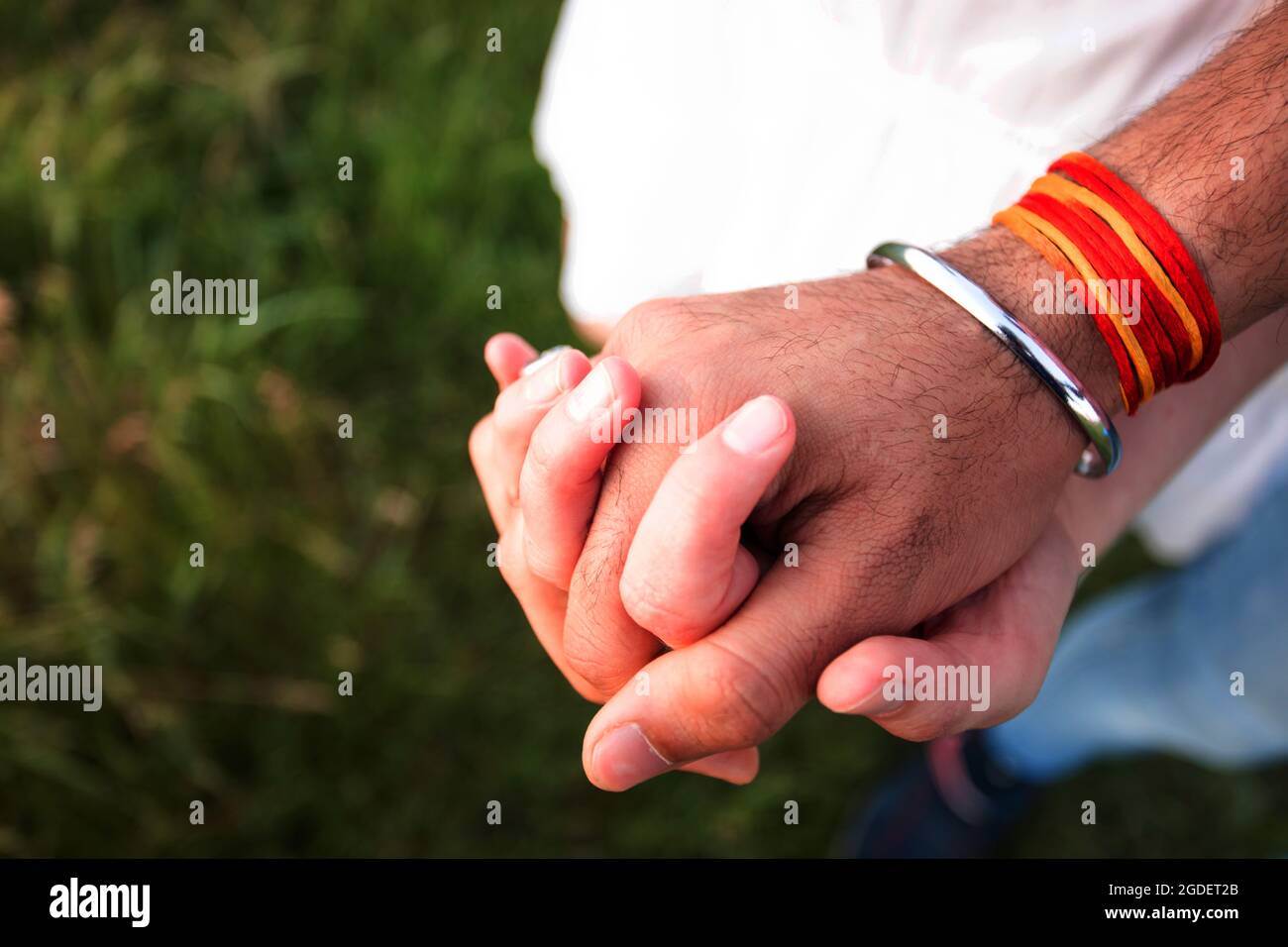 Romantic couple holding hands in summer field at sunset Stock Photo