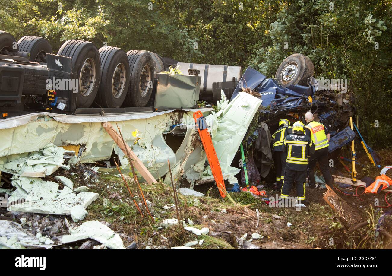 Talkau, Germany. 13th Aug, 2021. An articulated lorry loaded with fish lies next to the A24 motorway at the scene of an accident. The truck had left the roadway in the morning and overturned, the driver was killed in the accident. Credit: Daniel Bockwoldt/dpa/Alamy Live News Stock Photo