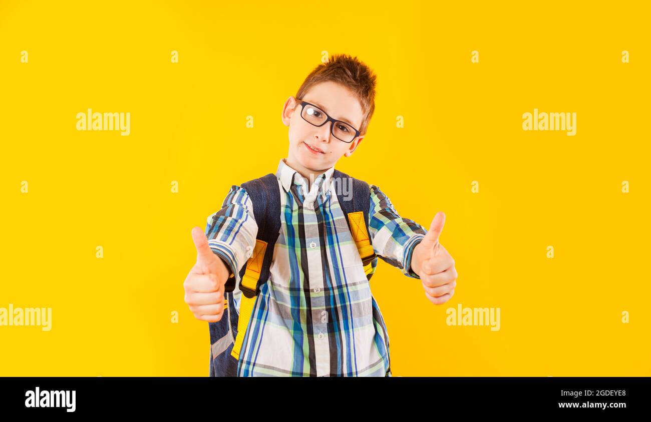 The smart schoolboy shows thumbs up in studio Stock Photo - Alamy