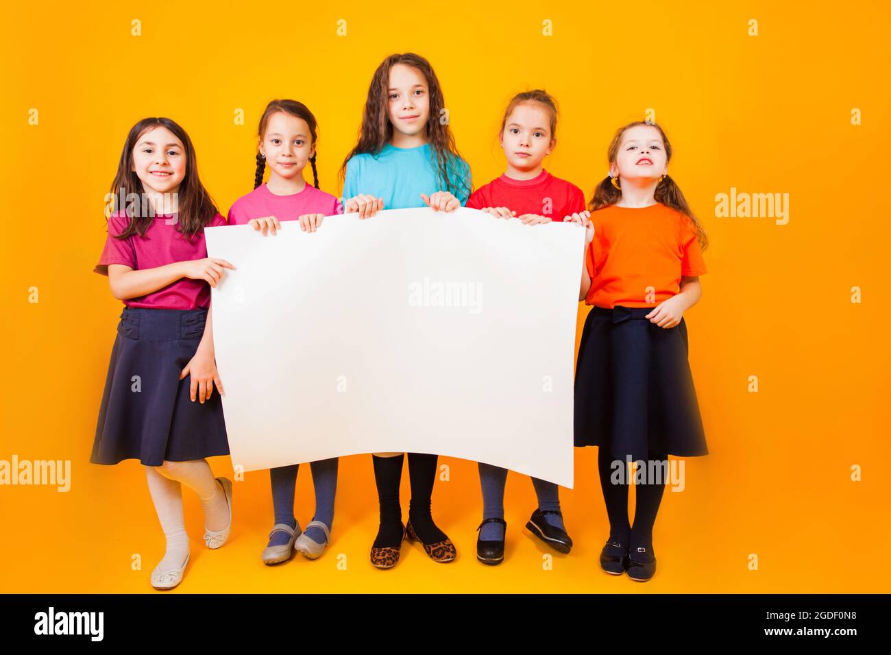 The different little boys are holding a big white paper Stock Photo - Alamy