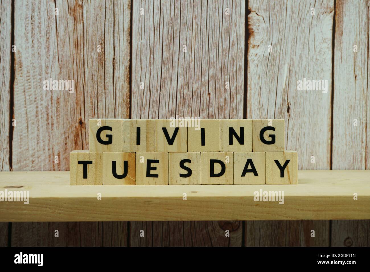 Giving Tuesday alphabet letter on wooden background Stock Photo