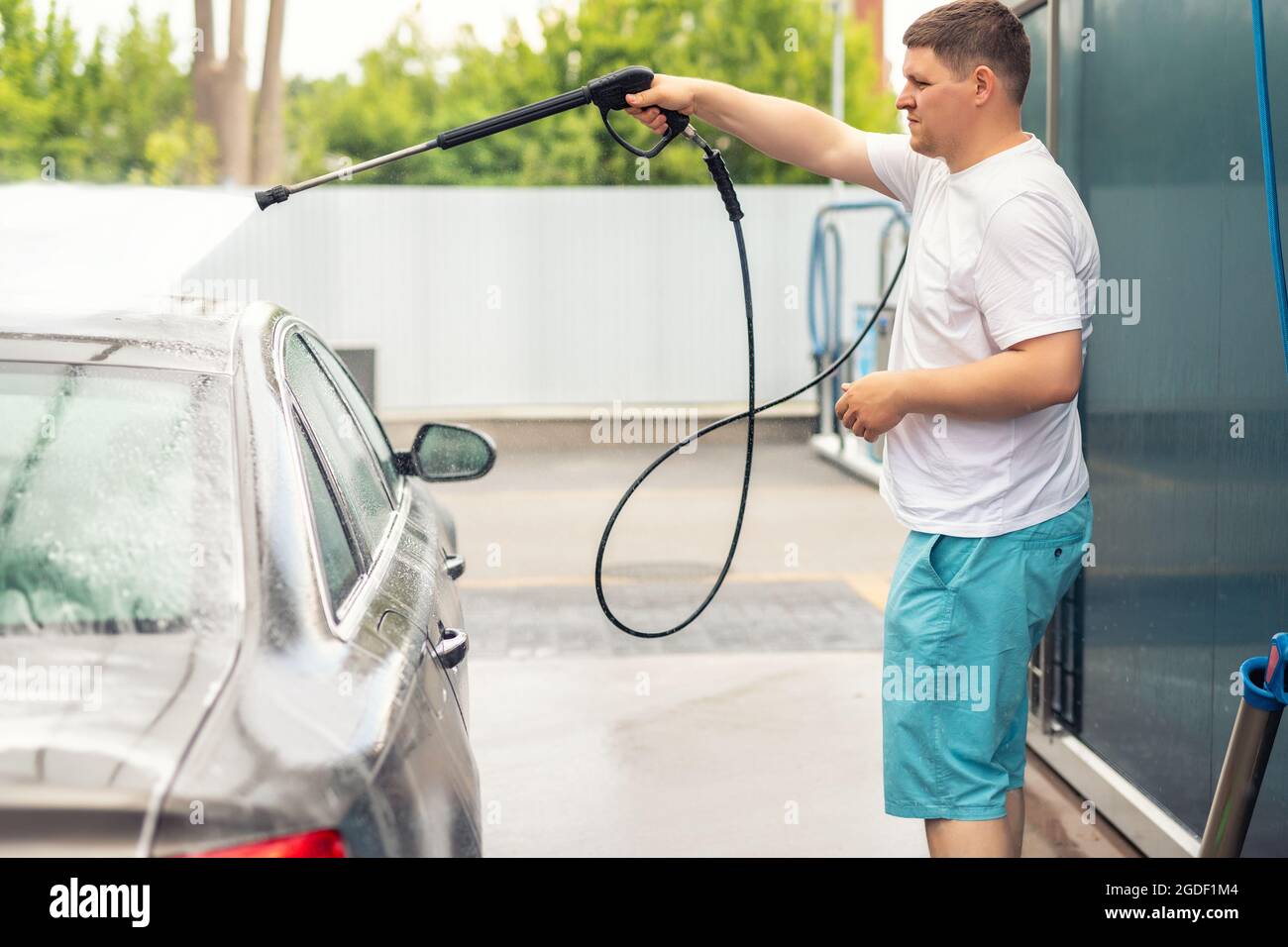 Premium Photo  Selfservice car wash a man washes off the foam