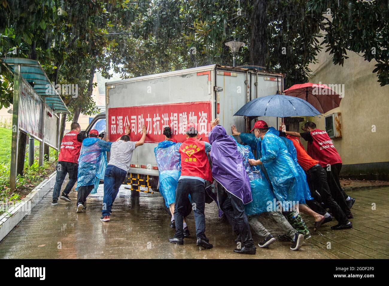 SUIZHOU, Aug. 13, 2021 (Xinhua) -- Staff members push a van loaded with disaster-relief supplies in Liulin Township of Suixian County, central China's Hubei Province, Aug. 13, 2021. Twenty-one people were killed and four others missing as heavy rain lashed Liulin Township from Wednesday to Thursday, local authorities said Friday. The Liulin Township saw total precipitation reaching 503 mm from 9 p.m. Wednesday to 9 a.m. Thursday, causing an average waterlogging depth of 3.5 meters, the county said in an announcement. Over 8,000 people have been affected in the township, acco Credit: Xinhua/Ala Stock Photo