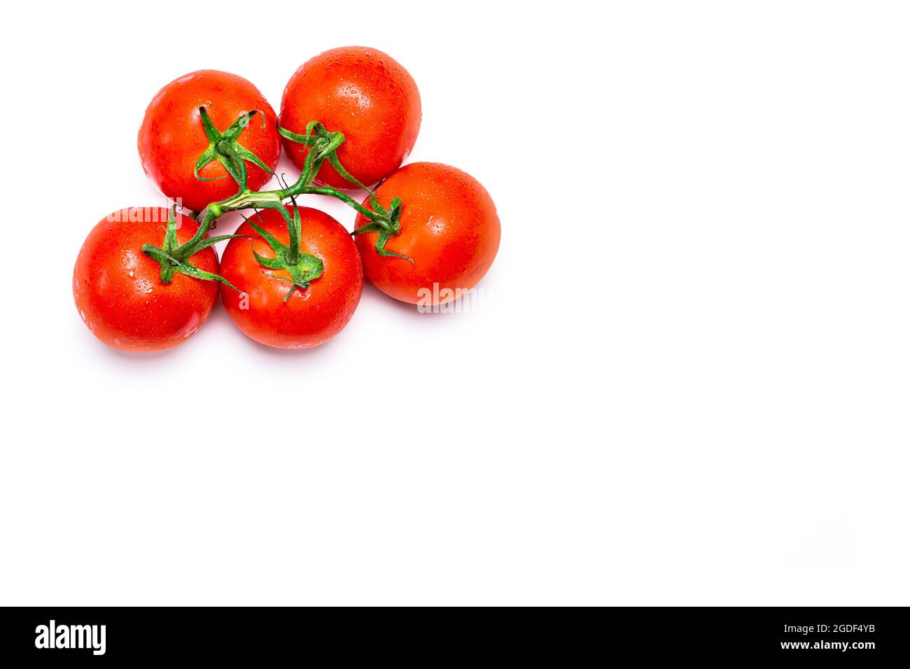 Overhead photograph of a bunch of five red natural tomatoes on a white background.The photo is taken in horizontal format and has copy space. Stock Photo