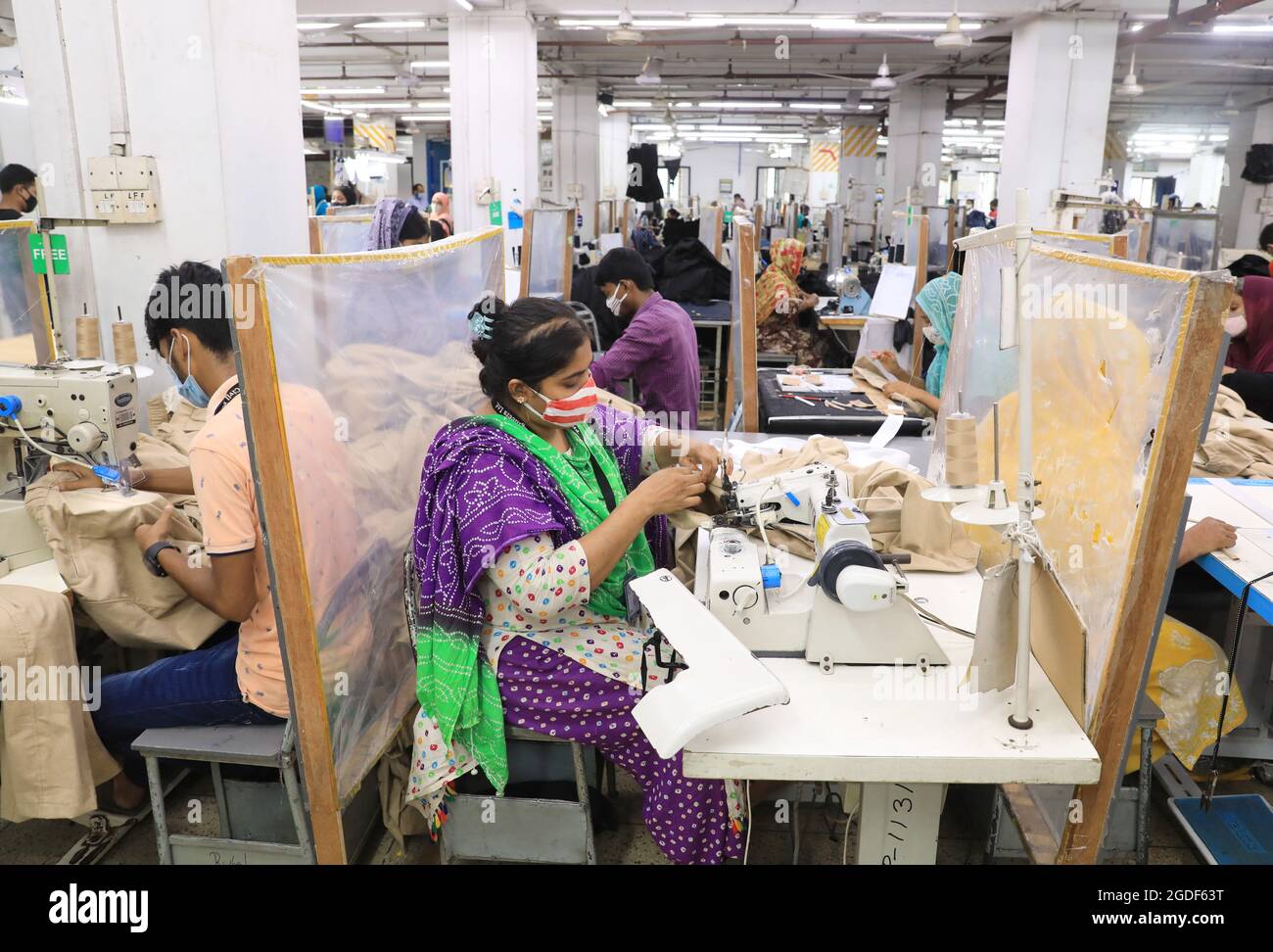 Non Exclusive: DHAKA, BANGLADESH - AUGUST 12: A woman manufactures clothes in a textile factory in the Gazipur industrial zone on the outskirts of Dha Stock Photo