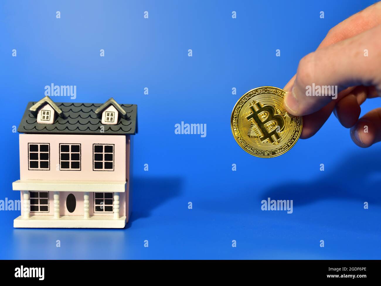 Purchasing property with Bitcoin Payments. Concept of buying real estate  and housing for cryptocurrency. BTC crypto coin and miniature house on blue  b Stock Photo - Alamy