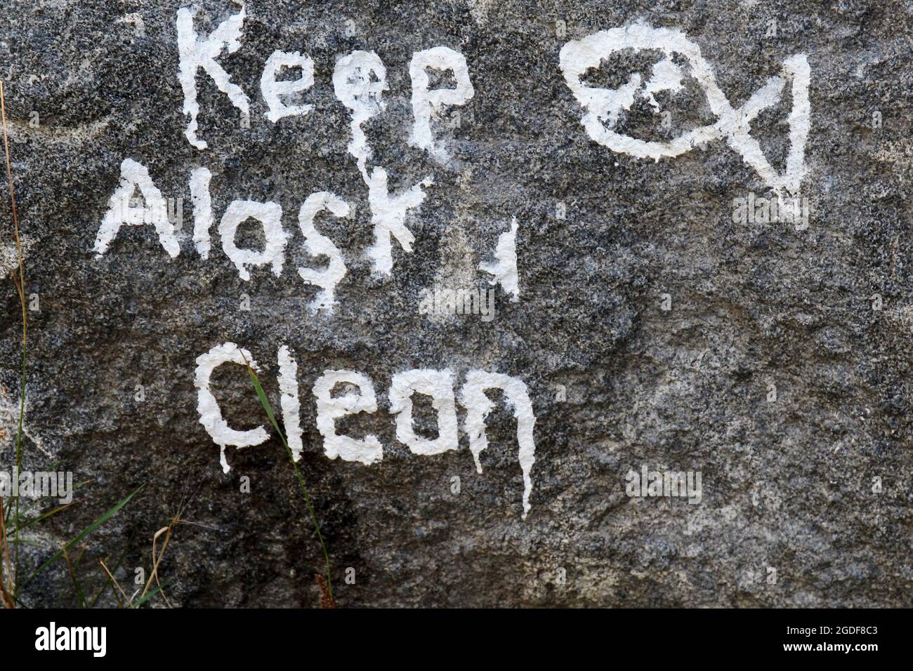 Keep Alaska Clean Spruch mit einem Fischsymbol in weißer Farbe auf einem Stein gemalt, in Alaska, USA. Stock Photo