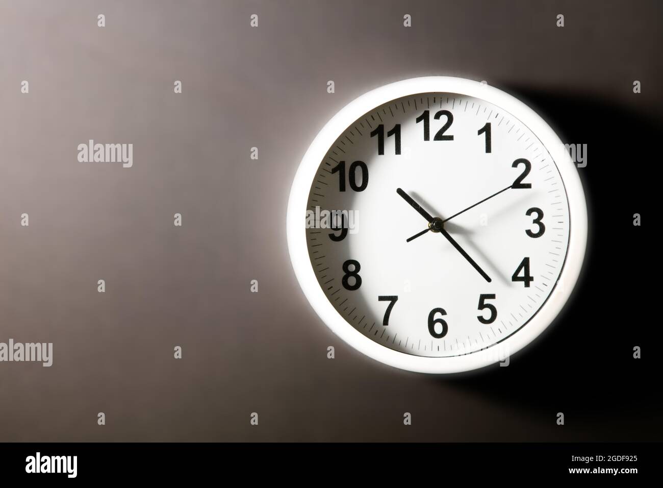 Modern white Wall Clock with black time pointer off center on black