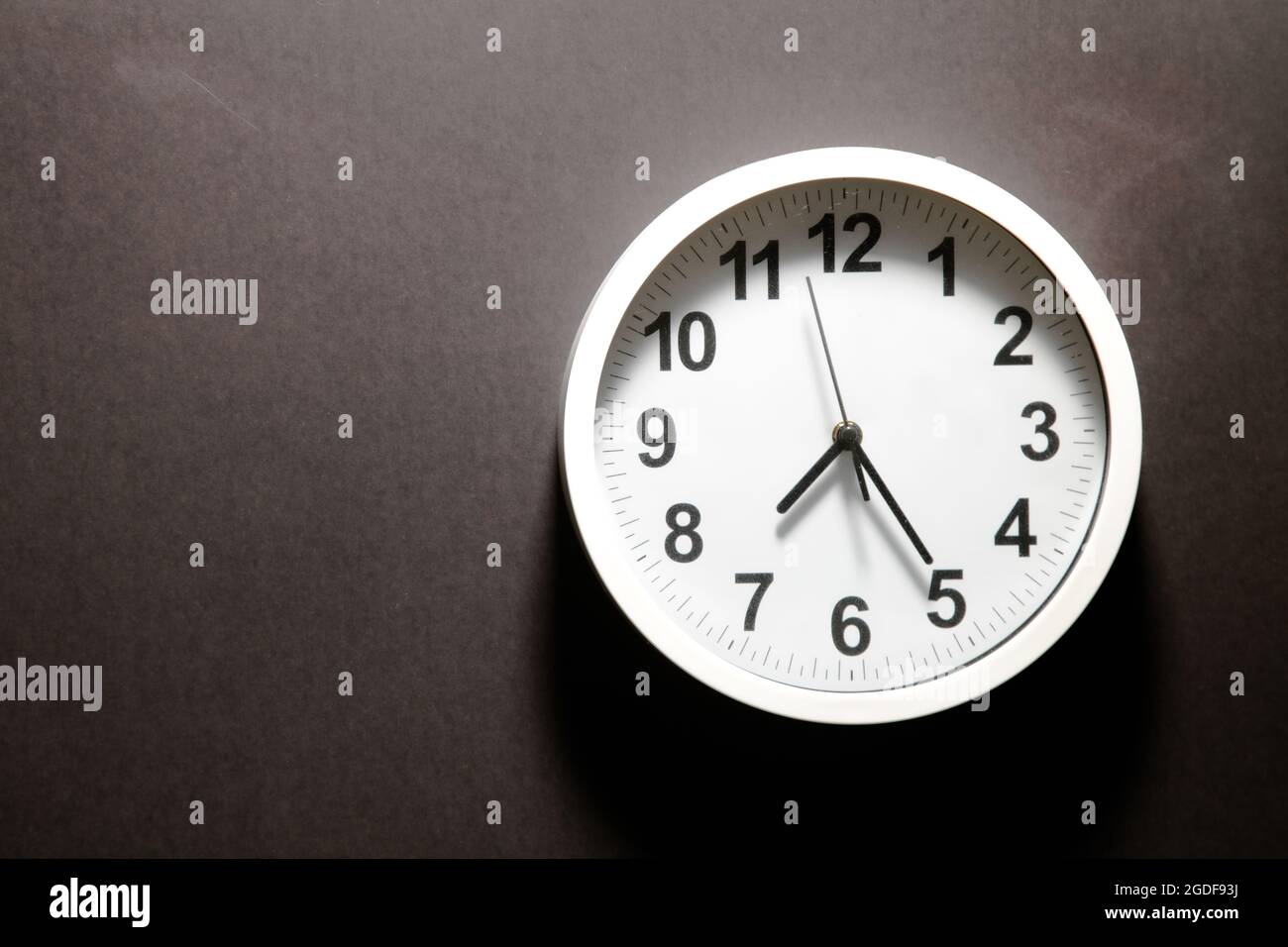 Modern white Wall Clock with black time pointer off center on black