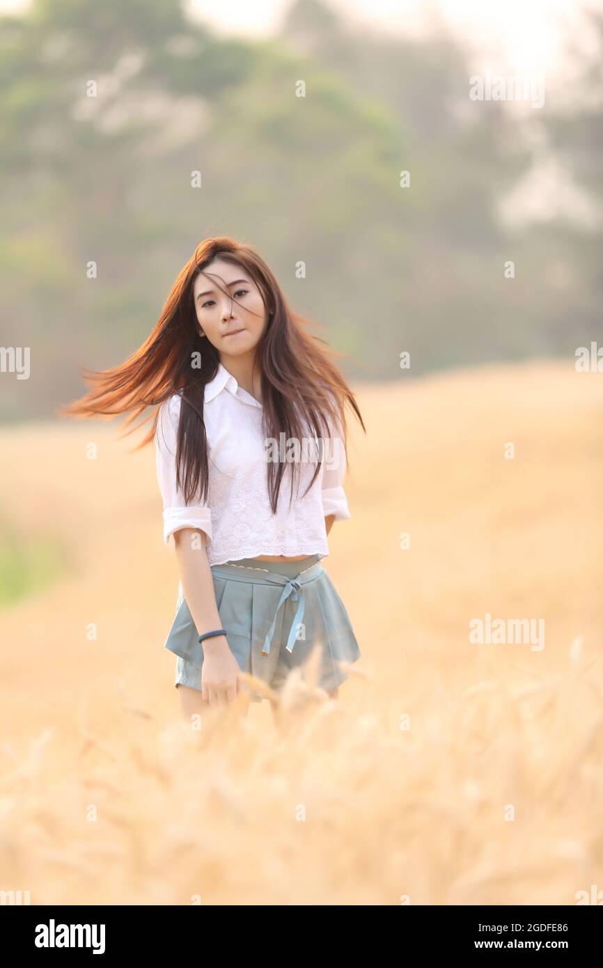Asian girl on wheat field Stock Photo - Alamy