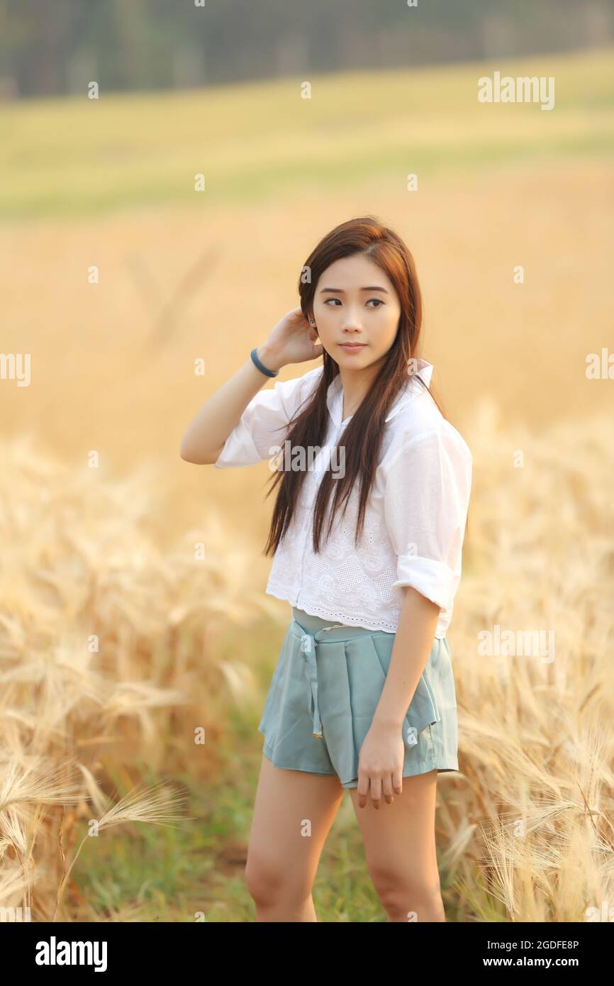 Asian girl on wheat field Stock Photo - Alamy