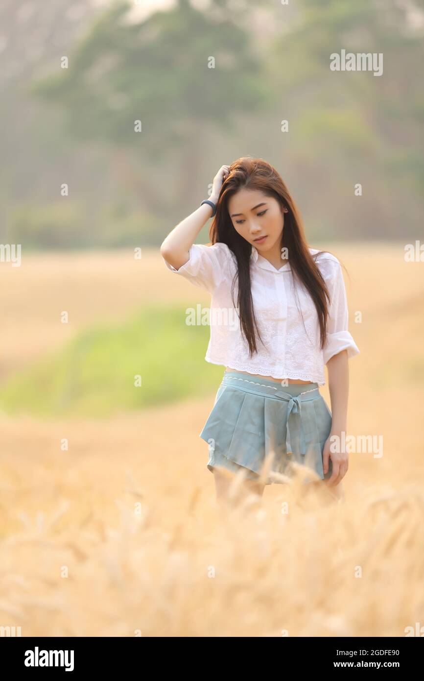 Asian girl on wheat field Stock Photo - Alamy