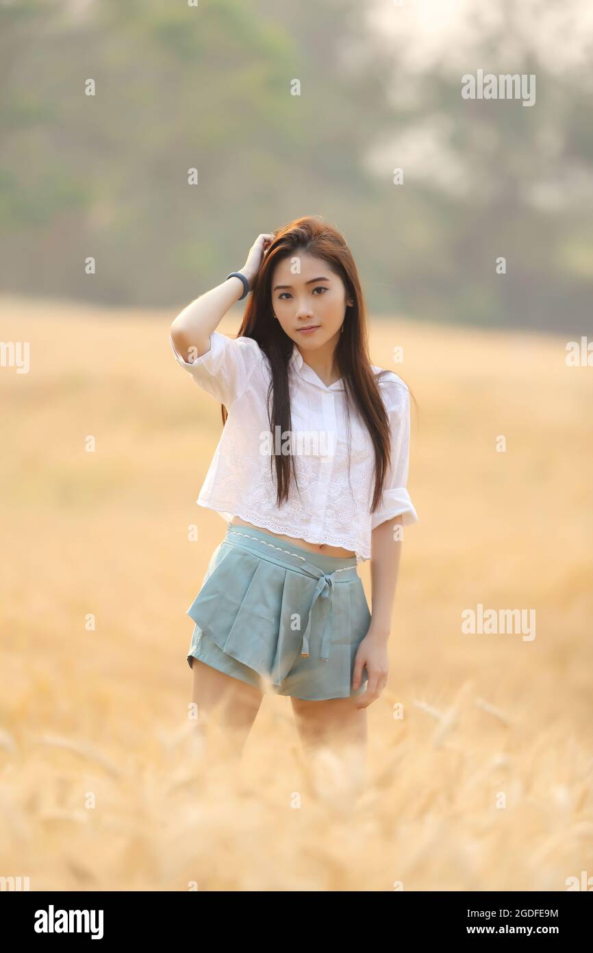 Asian girl on wheat field Stock Photo - Alamy