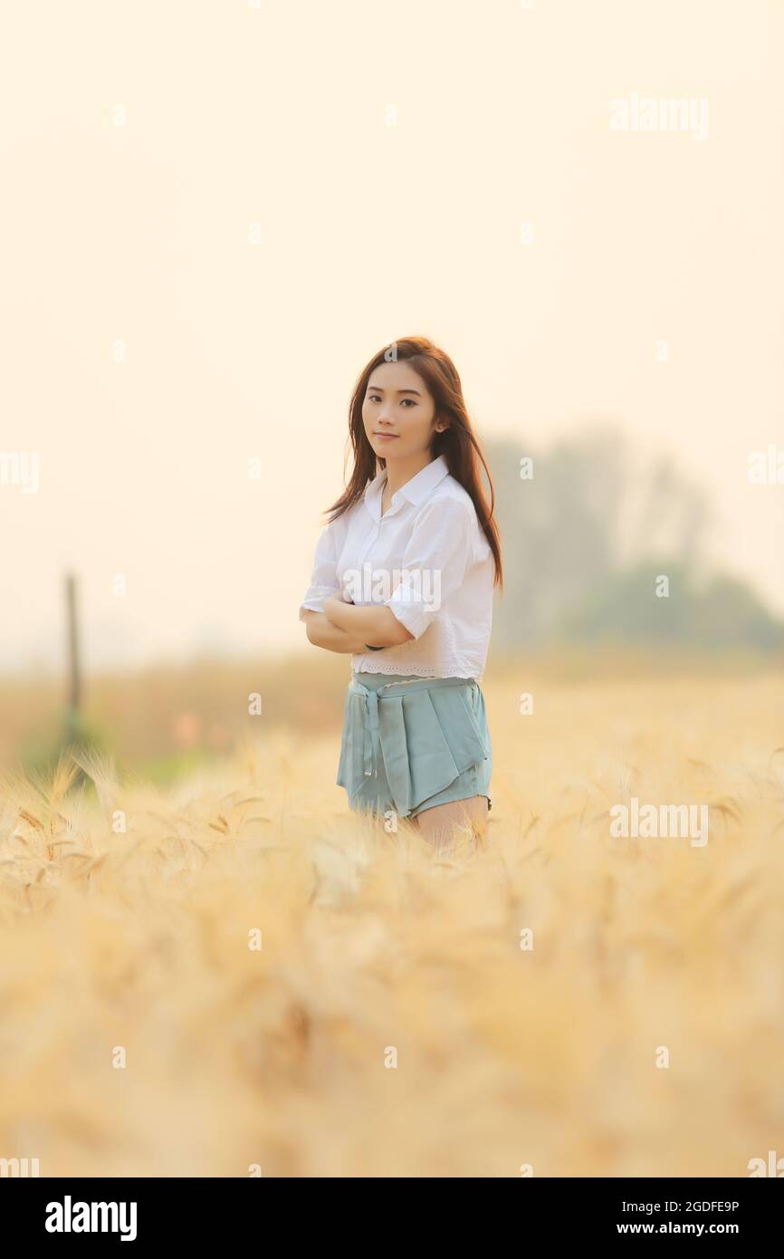 Asian girl on wheat field Stock Photo - Alamy