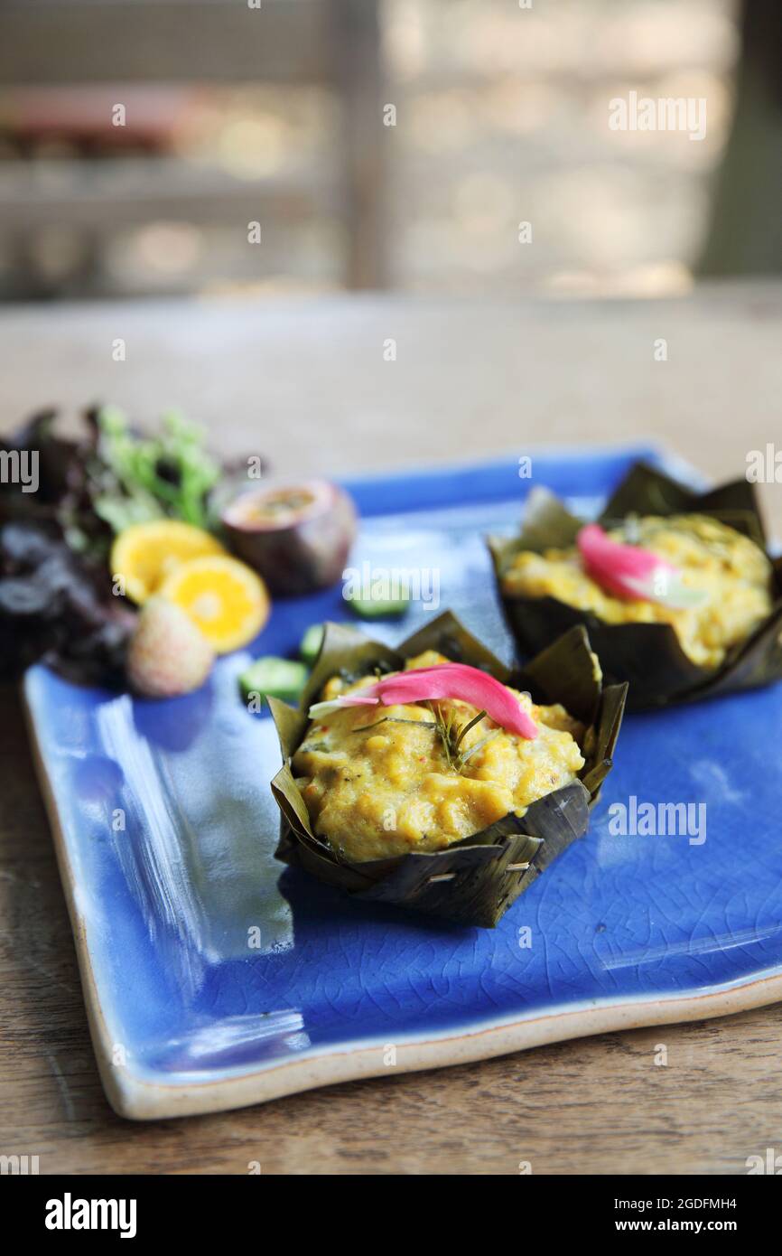 steamed fish with curry paste on wood background Stock Photo - Alamy