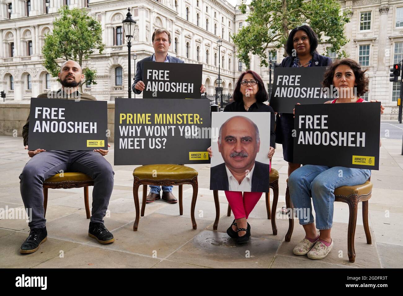 (Left to right) Aryan Ashoori, the son of Anoosheh Ashoori, Richard Ratcliffe, Sherry Izadi, the wife of Anoosheh Ashoori, MP for Lewisham East Janet Daby and Elika Ashoori, the daughter of Anoosheh Ashoori, a British man who has been jailed in Iran, stage an 'empty chair' protest opposite Downing Street, London, marking the 4th anniversary of his imprisonment. Picture date: Friday August 13, 2021. Stock Photo