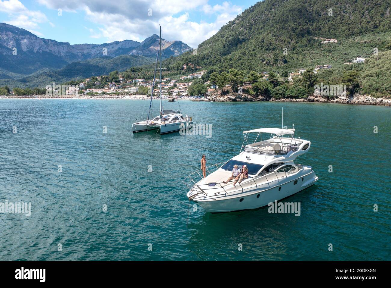 Aerial view of a luxury motor yacht and catamaran sailing the sea Stock
