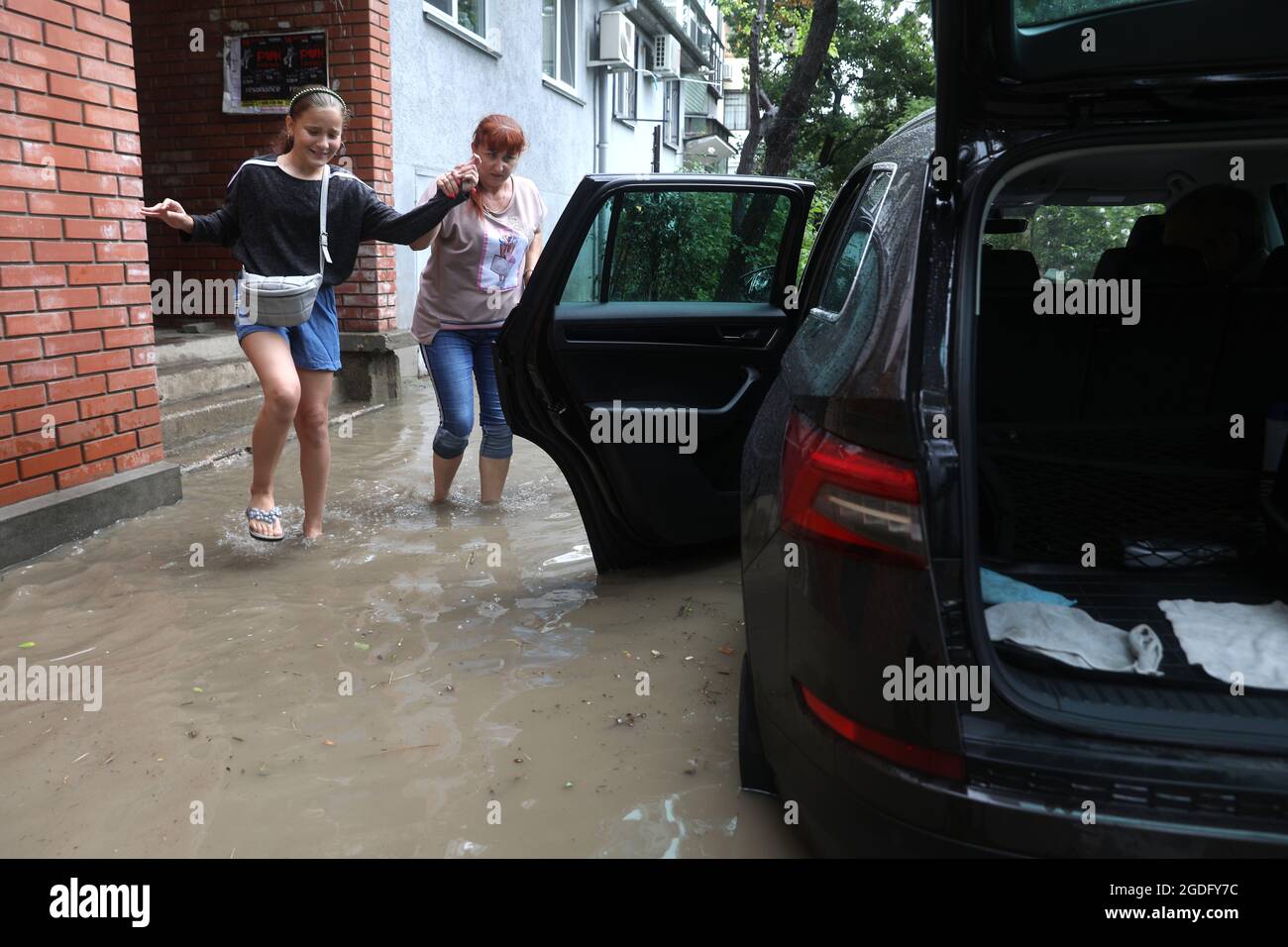 Kerch, Crimea, Russia. 13th Aug, 2021. Local residents leave a flood-hit  area in the city of Kerch. Heavy rains caused a rise in water levels in  local rivers which led to the