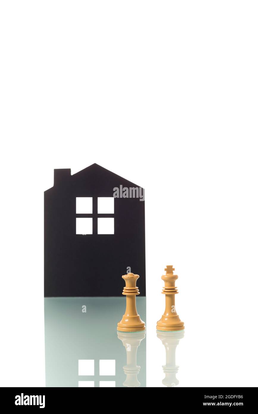 Conceptual photograph of two white chess pieces (king and queen) metaphorically representing a childless white heterosexual couple, with the silhouett Stock Photo