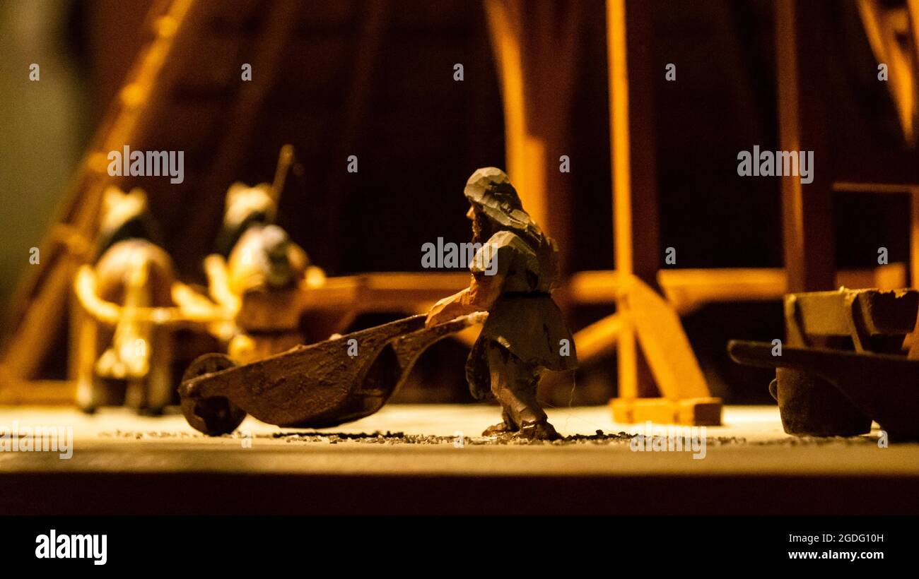 Small wooden figurine carrying a wheelbarrow Stock Photo - Alamy