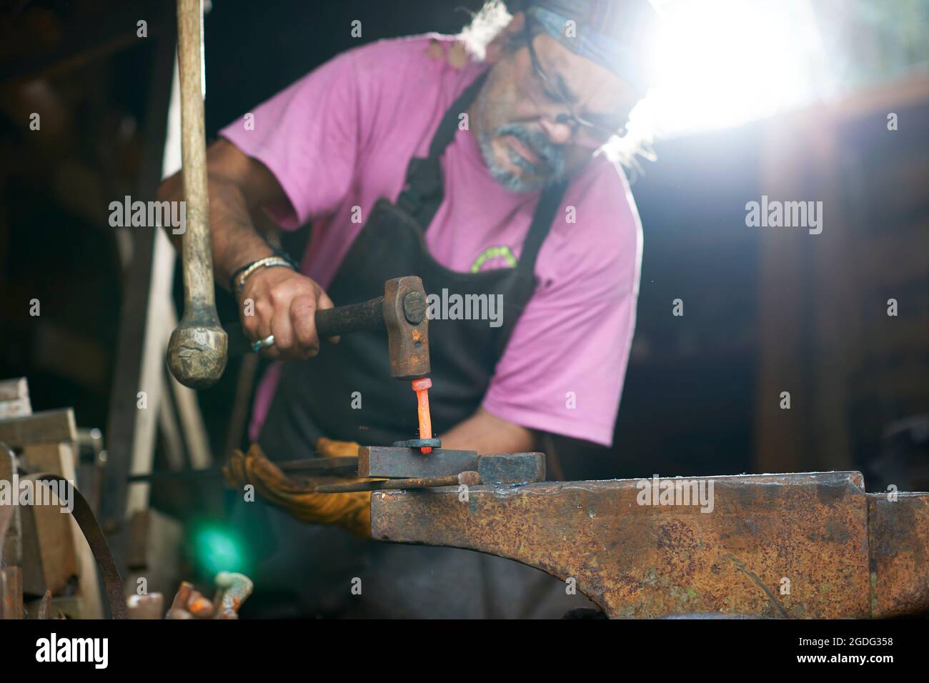 Blacksmith working in his forge Stock Photo