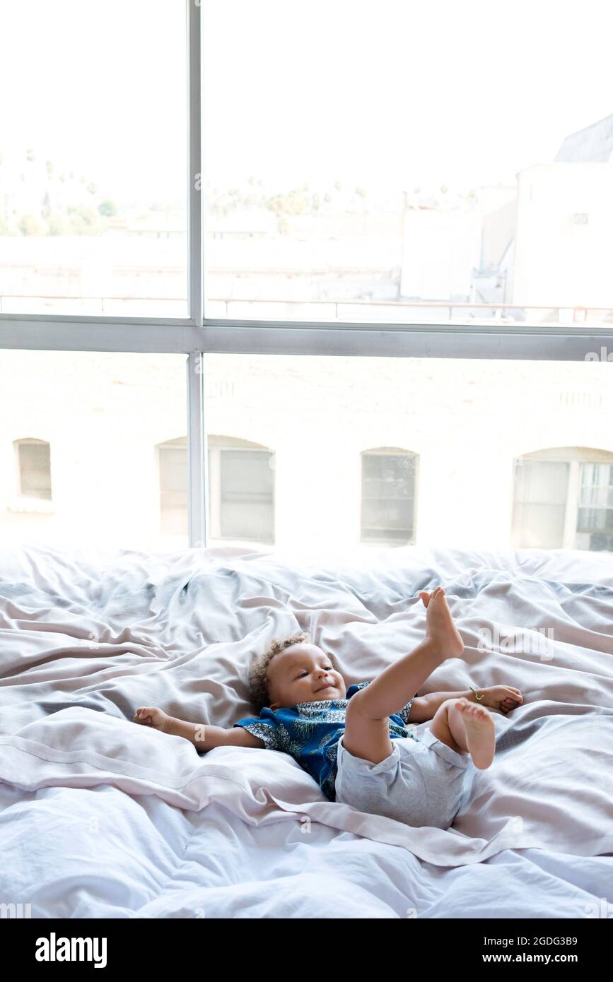 Toddler playing on bed Stock Photo