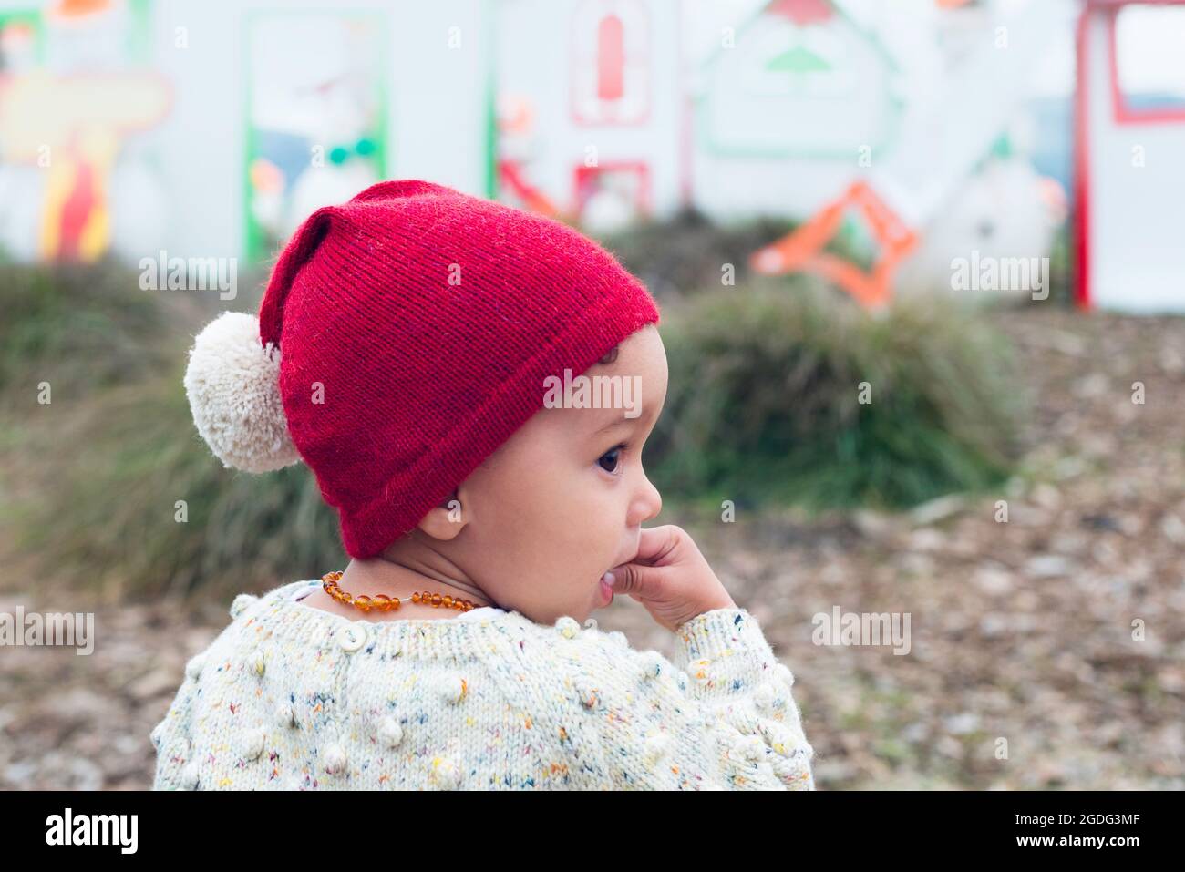 Toddler in red beanie with pom pom Stock Photo