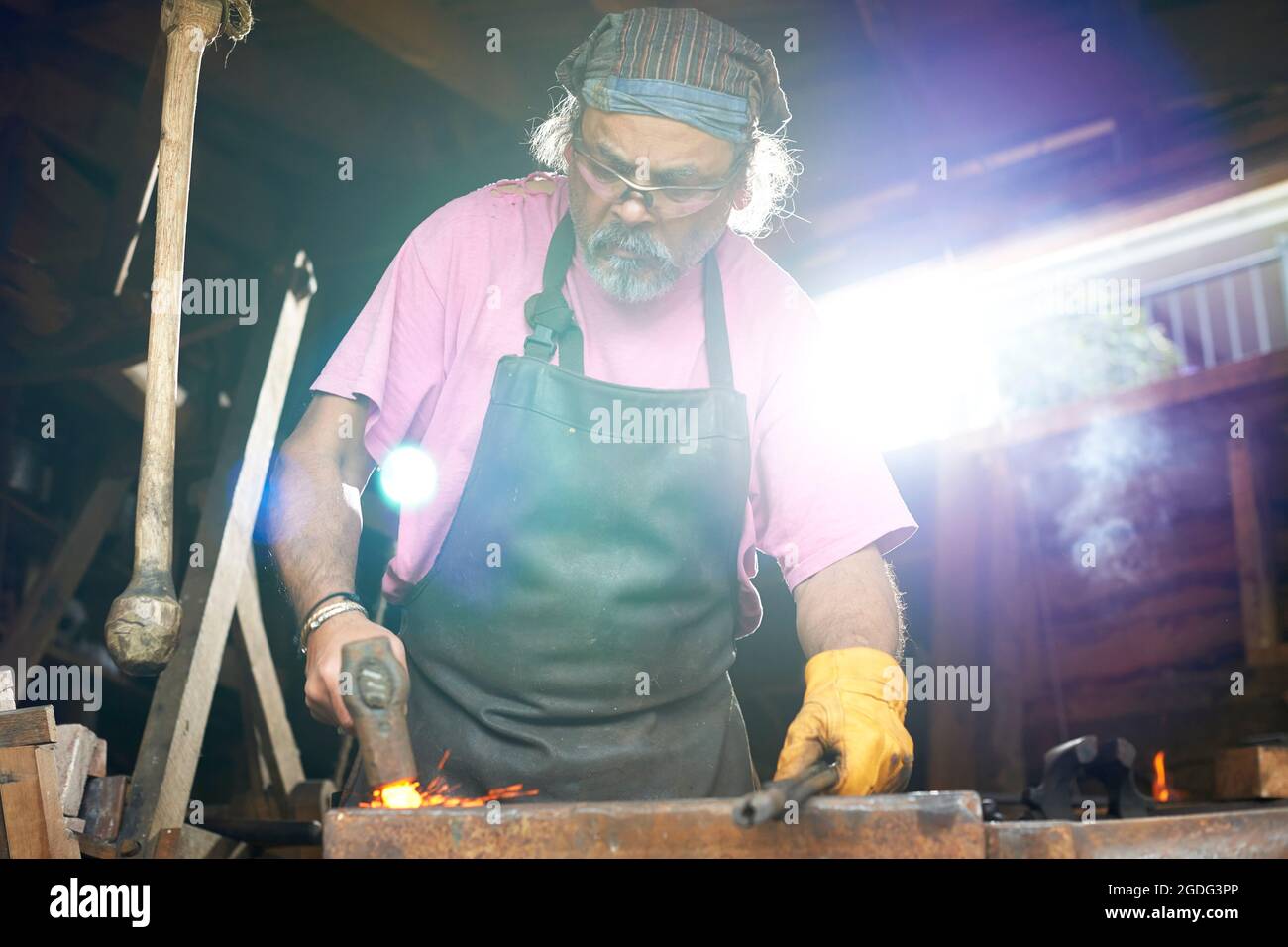 Blacksmith working in his forge Stock Photo
