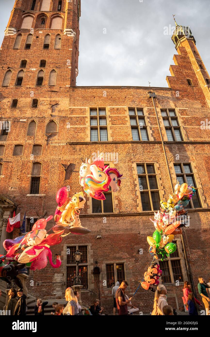 Balloons sold in the old town of Gdańsk against the background of the town hall. History and commercialization. Stock Photo