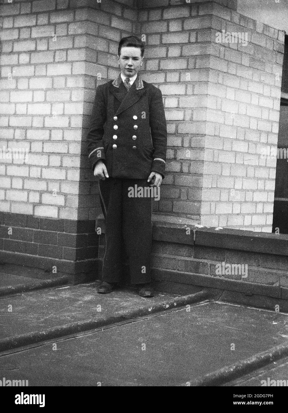 1940s, historical, hotel bell boy in his uniform standing on a flat roofed area of the hotel, London, England, UK. Traditionally, the young man would act as an attendant or porter, helping guests with their luggage and run general errands. Also known as a bellhop. Stock Photo