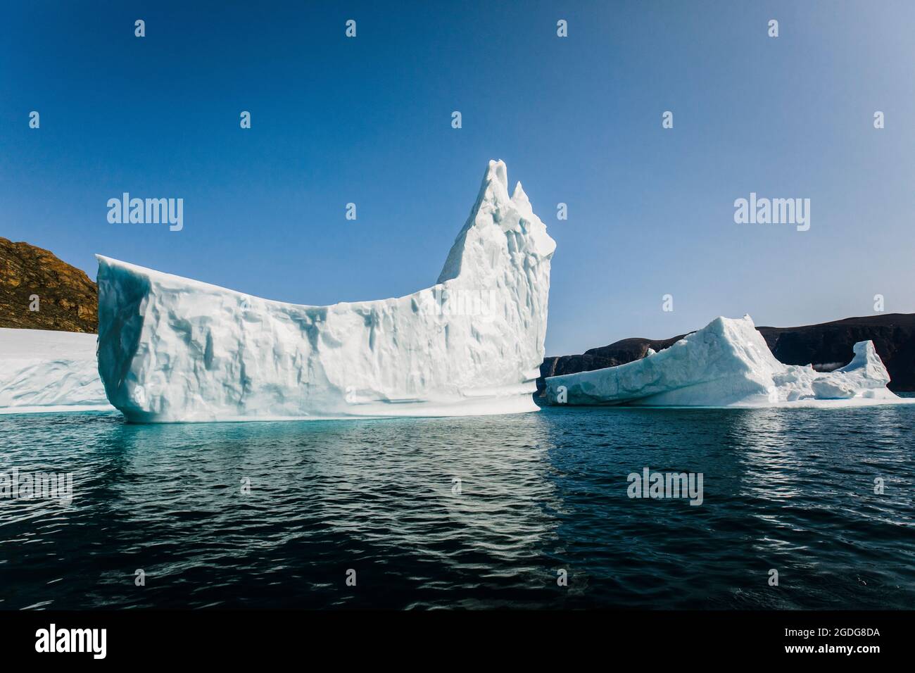 Iceberg floating in ocean in the shape of a ship Stock Photo