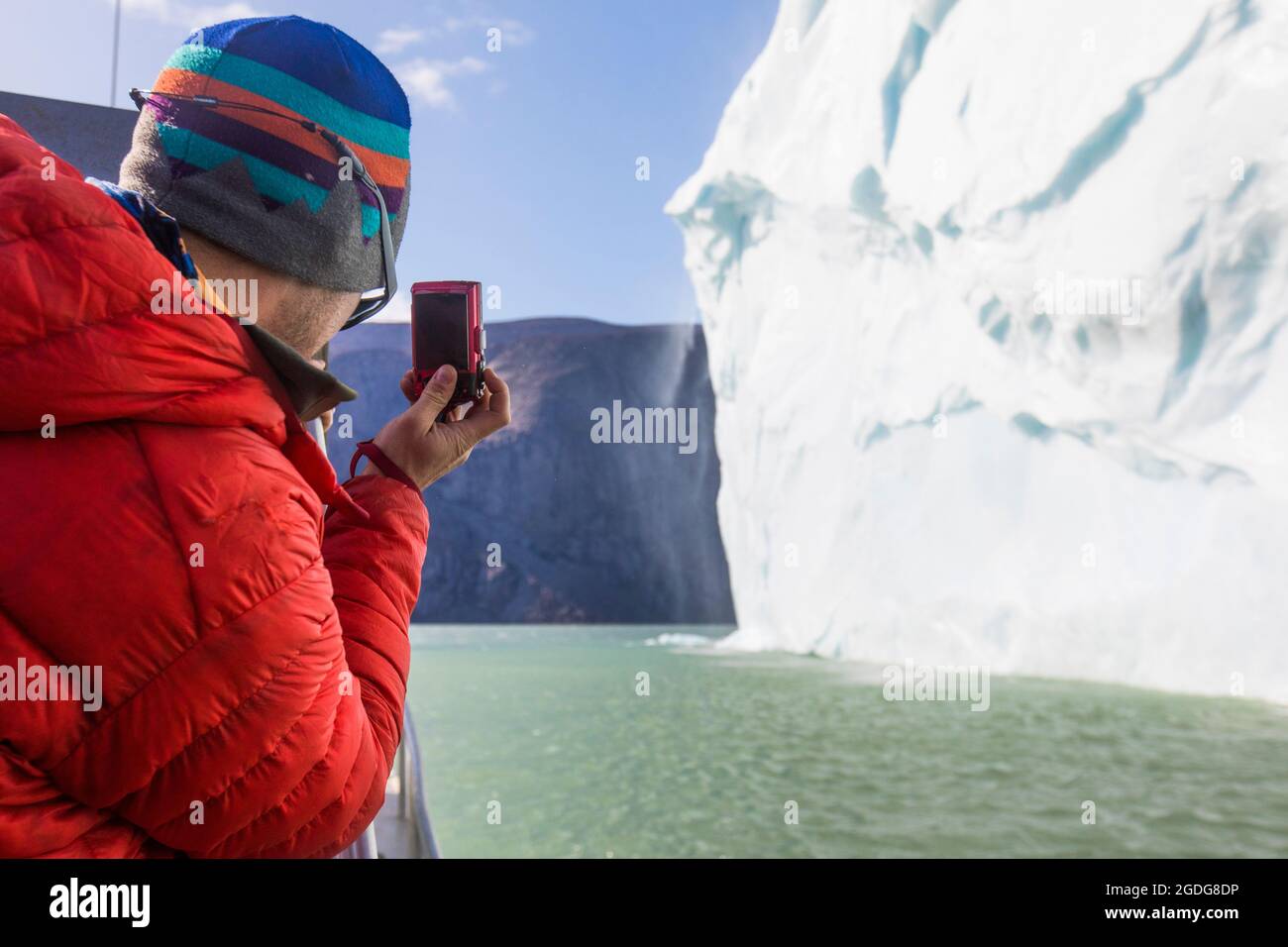 Man takes photo of melting iceberg. Stock Photo