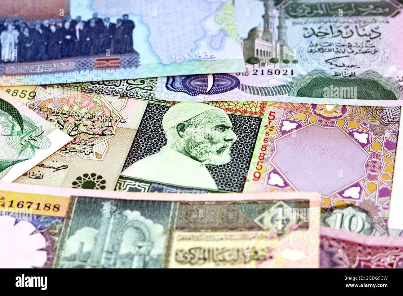 Background of Libyan money dinars banknotes with portraits of Omar Al-Mukhtar on some banknotes, selective focus of different banknotes from Libya Stock Photo