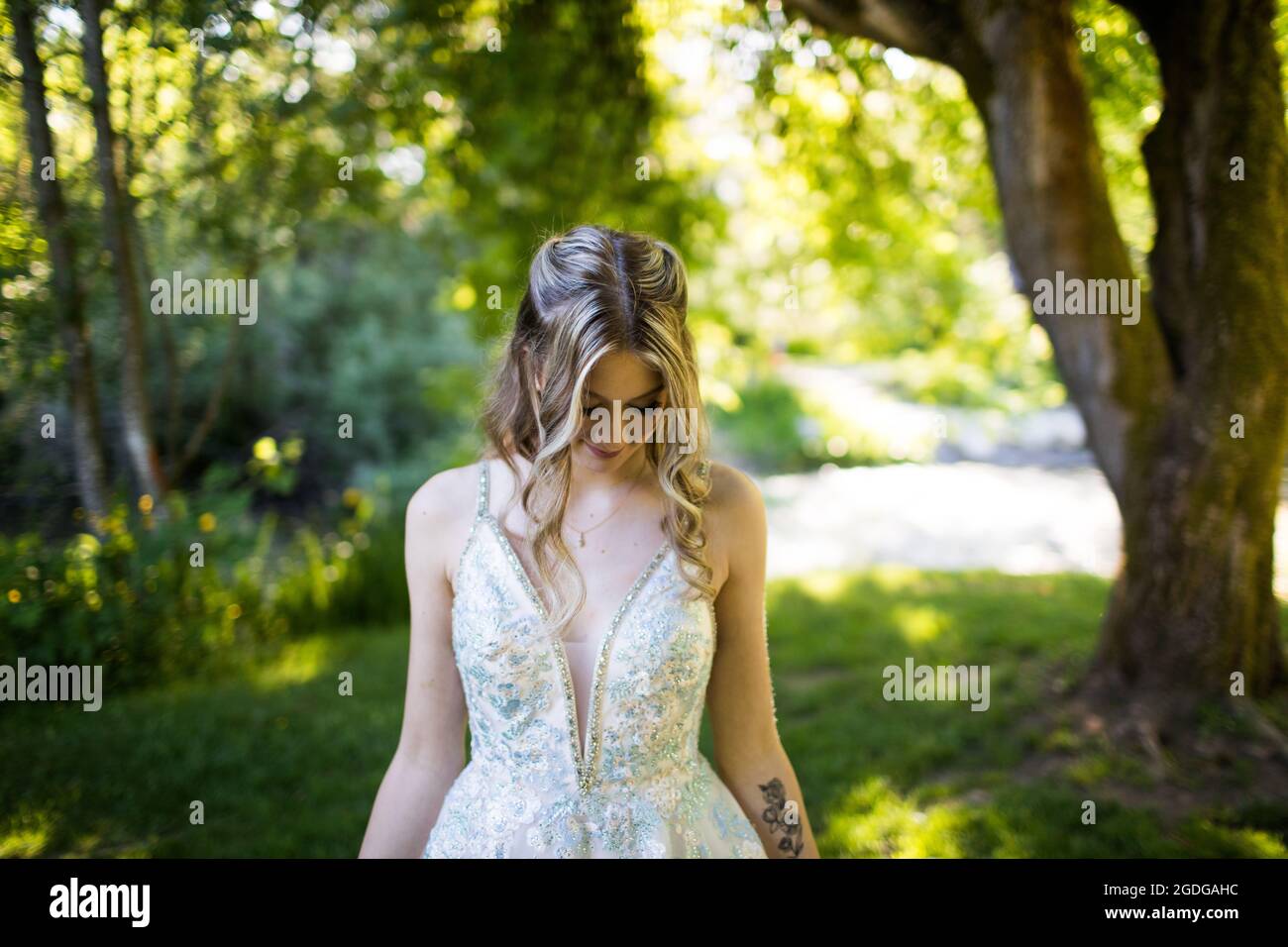 Portrait of attractive young woman looking down in nature. Stock Photo