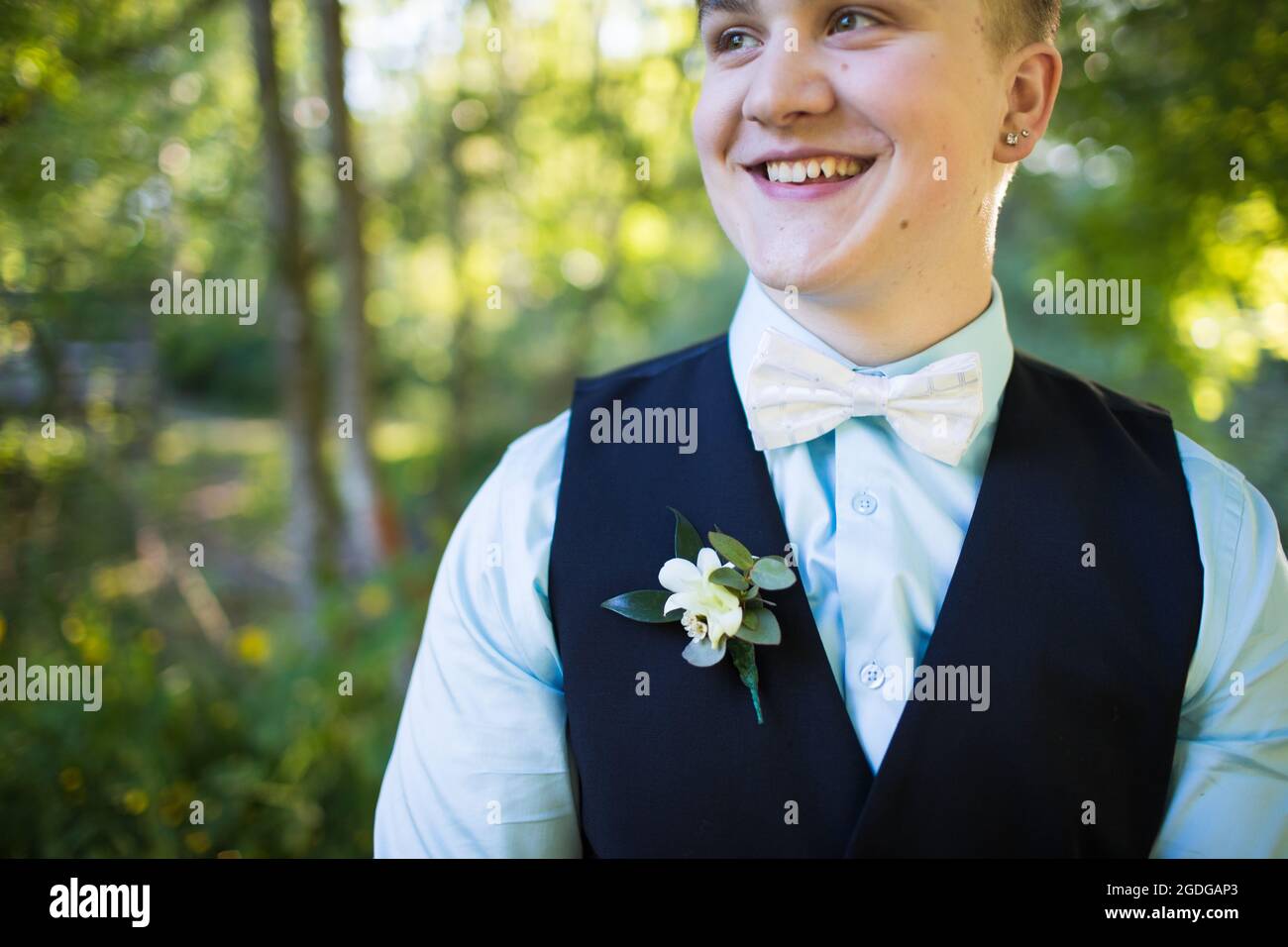 Cropped portrait of young man smiling, wearing boutonniere Stock Photo