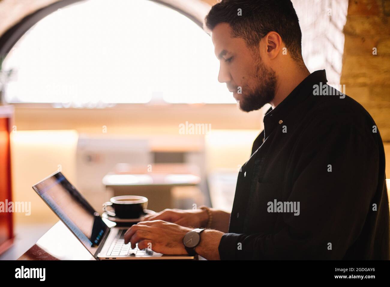 Serious man using laptop computer at cafe Stock Photo