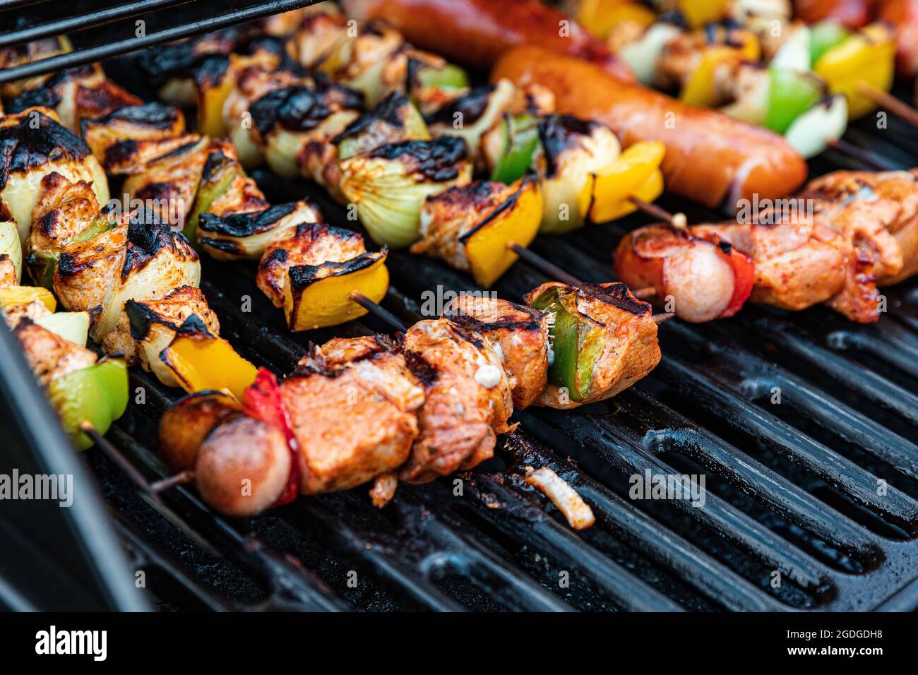 assorted delicious grilled meat with vegetables and sausages on ...