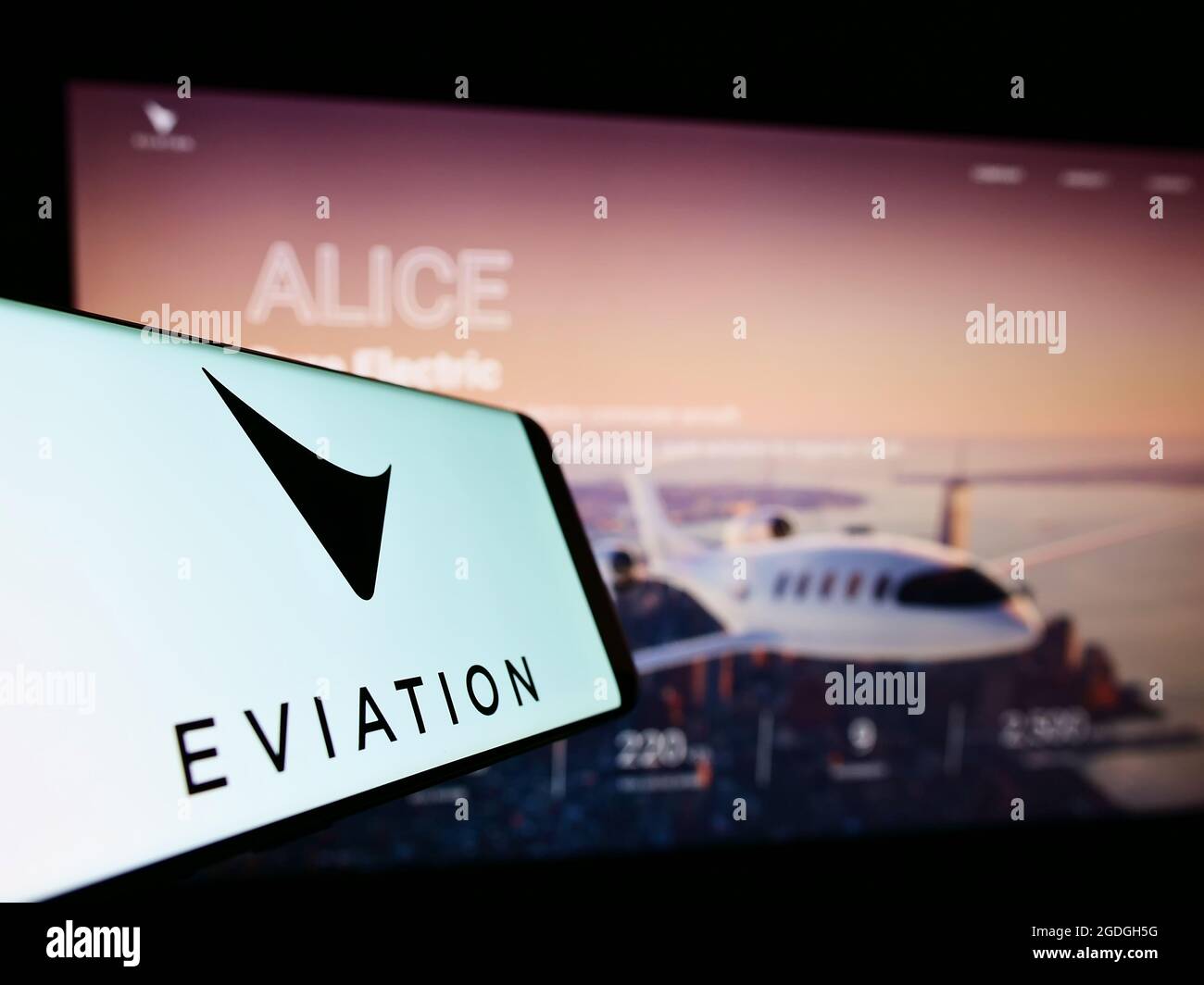 Mobile phone with logo of electric aircraft company Eviation Aircraft Ltd. on screen in front of website. Focus on center-right of phone display. Stock Photo