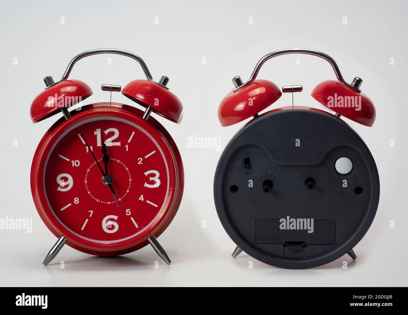 Red alarm clock seen from front and back isolated white background