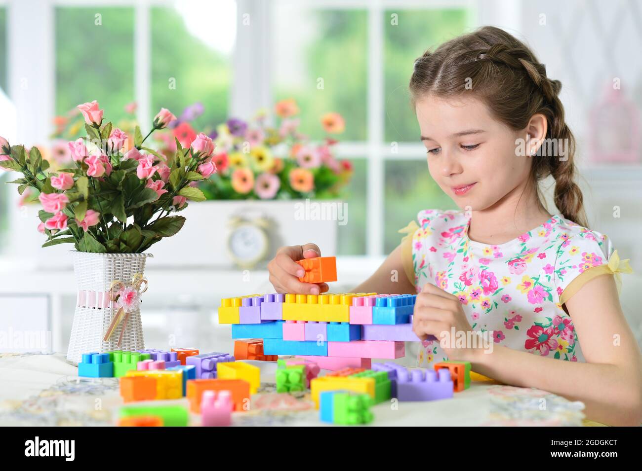 Portrait of girl playing with colorful plastic blocks Stock Photo - Alamy