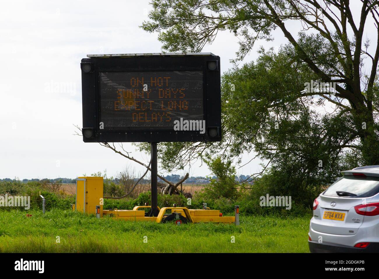 Roadside sign on the A259, On hot sunny days expect long delays for turning into Camber Sands, East Sussex, uk Stock Photo