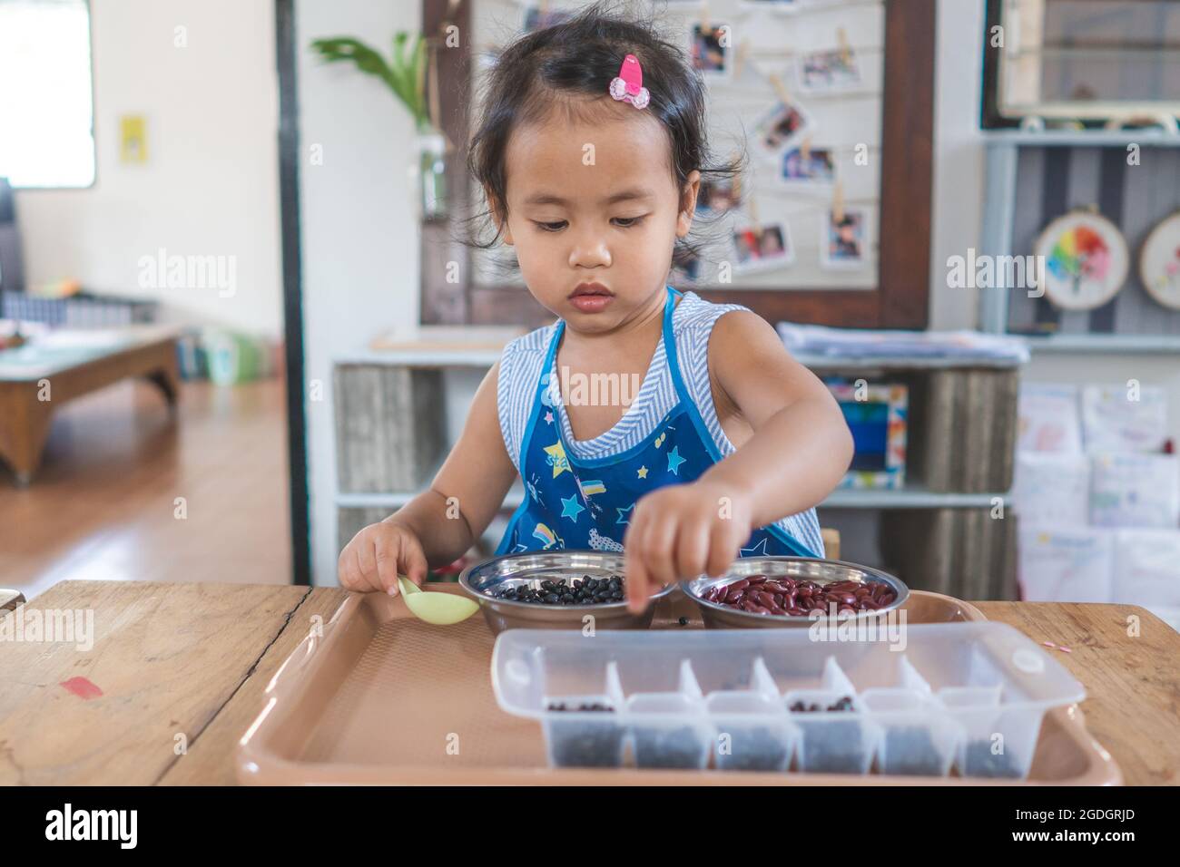 Closeup shot of a little Thai girl playing in the kitchen Stock Photo