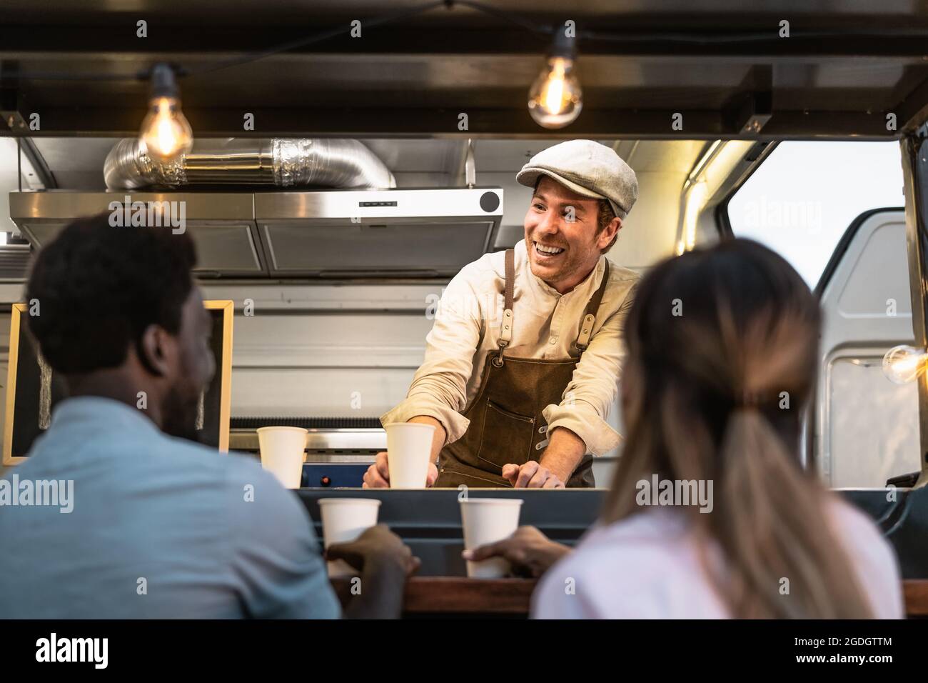 Happy multiracial people buying meal from street food truck market - Modern business and take away concept Stock Photo