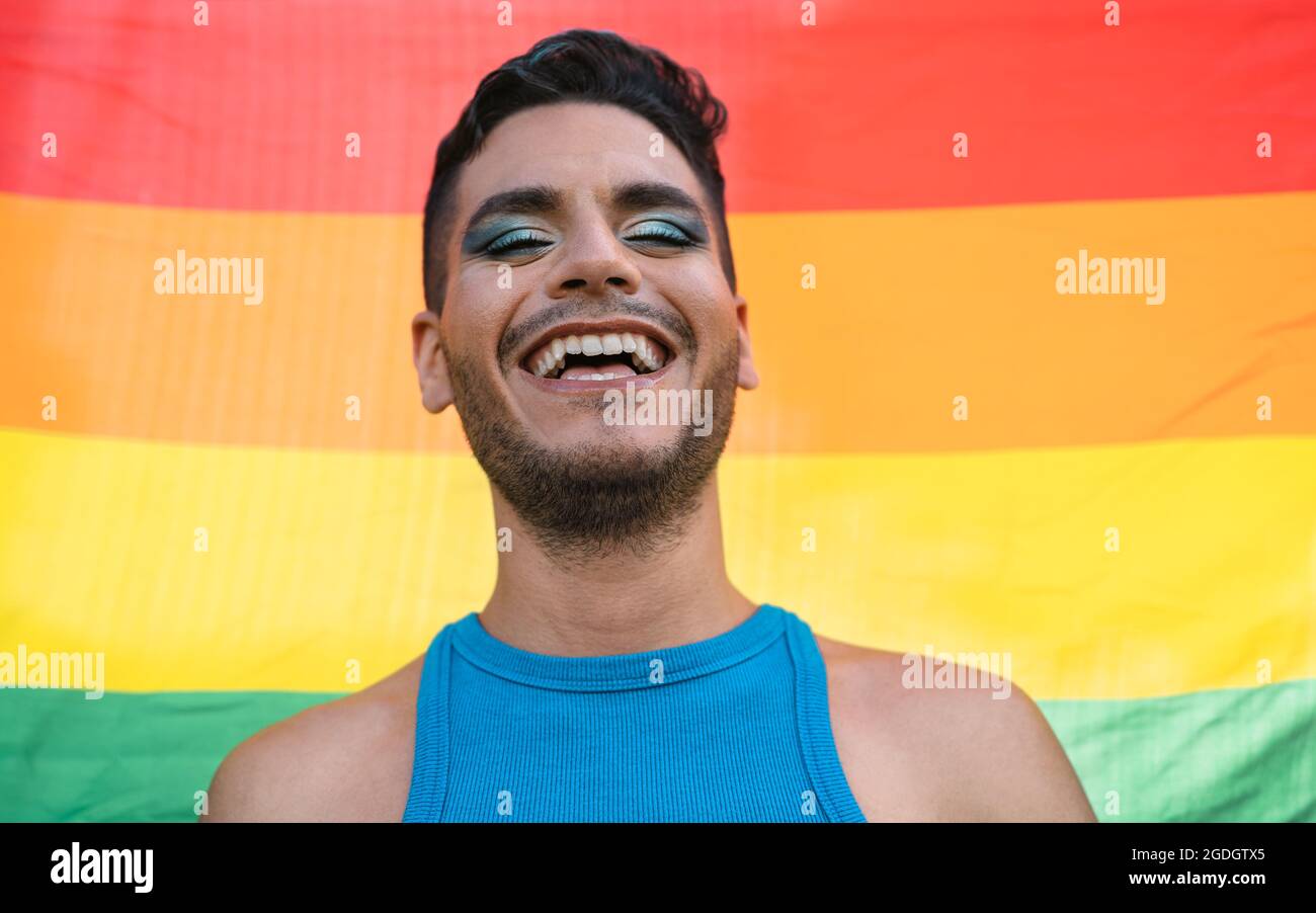 Happy homosexual man celebrating gay pride holding rainbow flag symbol of LGBTQ community Stock Photo